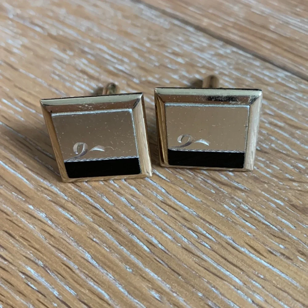 gold cuff links with silver and black accents